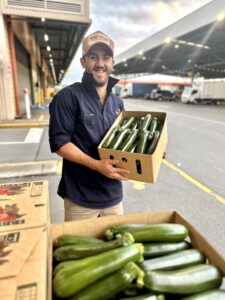 Man holding tray of zucchini