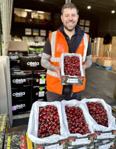 Man Holding Box of Cherries